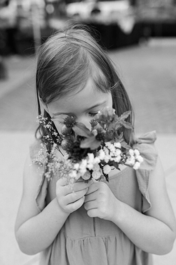 A little girl smells a wildflower bouquet