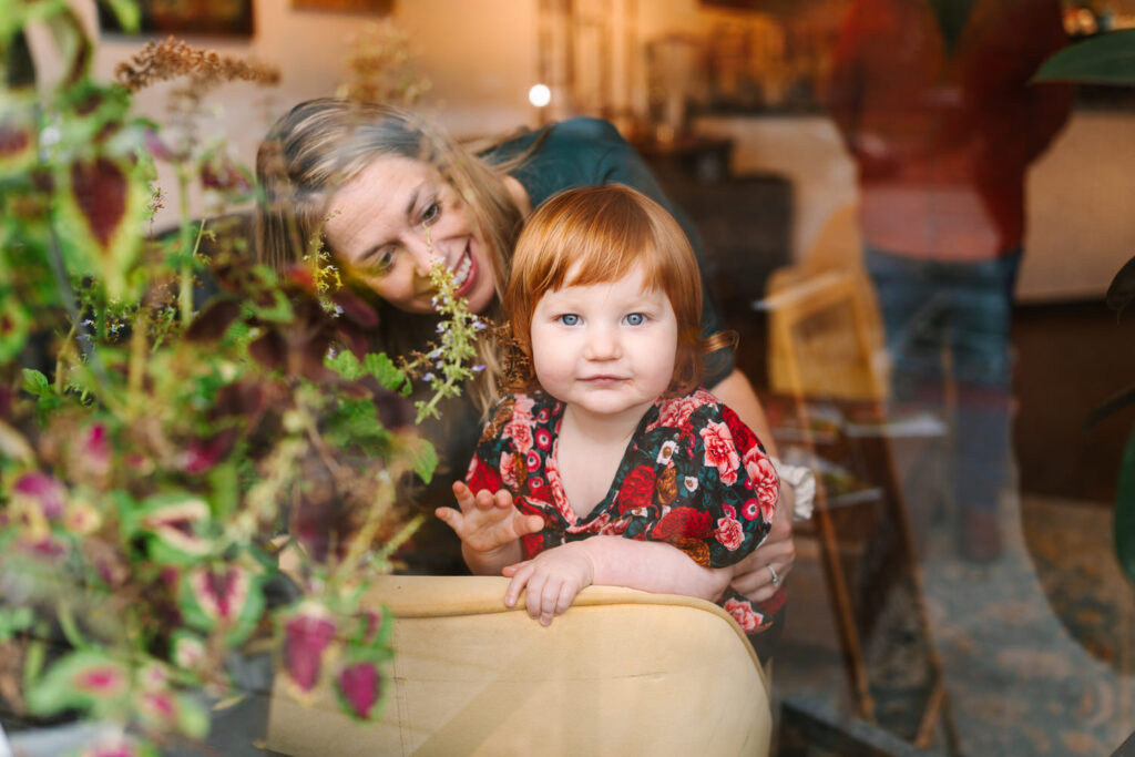 Tiffany and her young daughter Luna look out the glass window of a cafe in Grandview Heights, Ohio