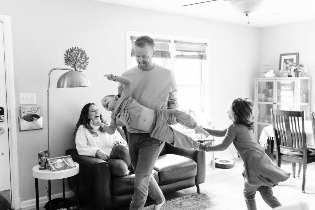 A family playfully wrestles in their living room in the Clintonville neighborhood of Columbus Ohio