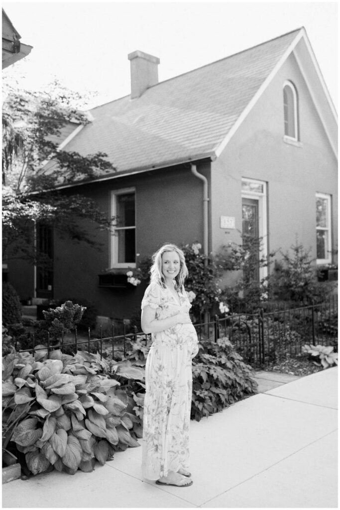 Pregnant lady standing in front of a house