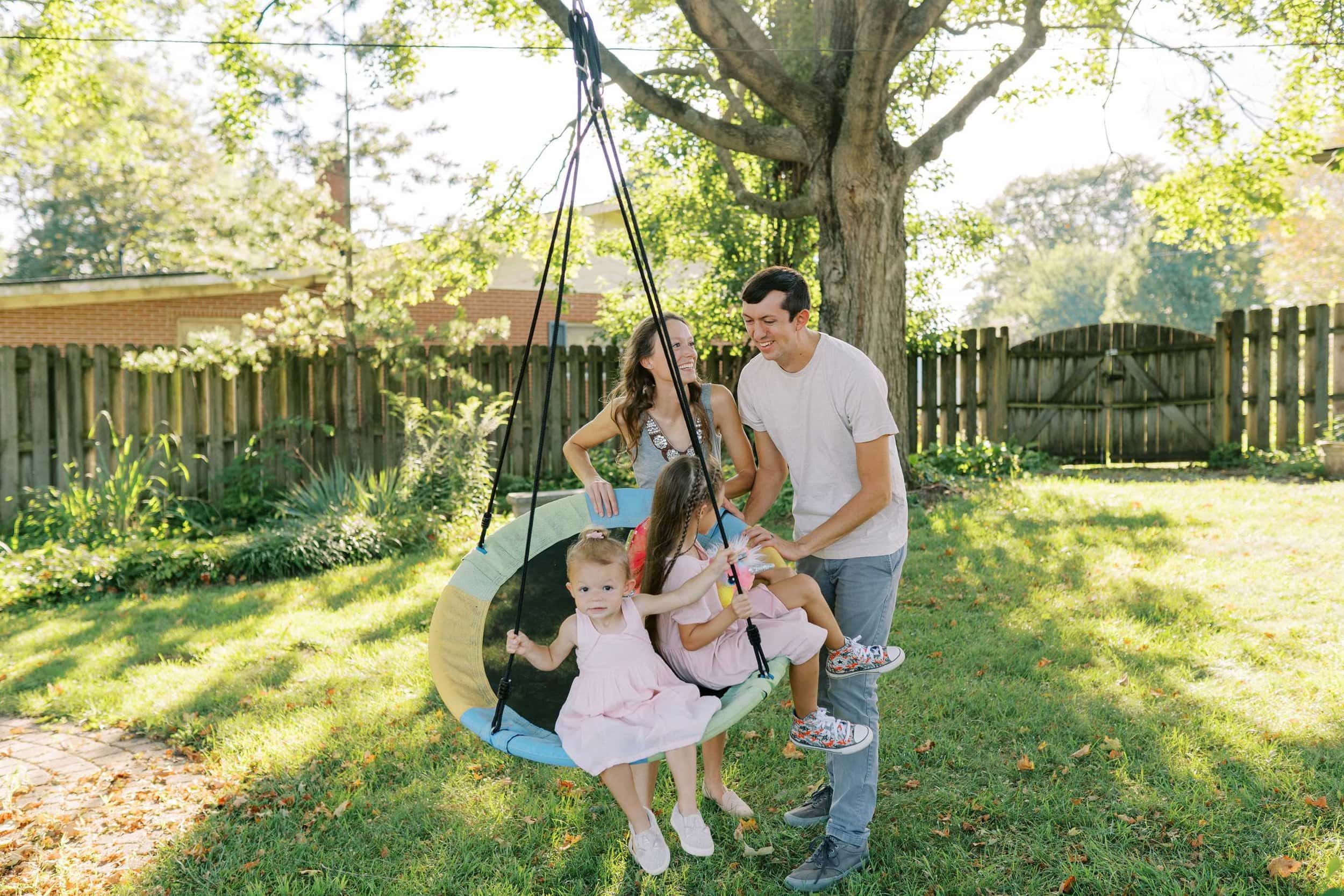 Keira and Ben push their two young daughters in a tree swing in their backyard in Columbus Ohio
