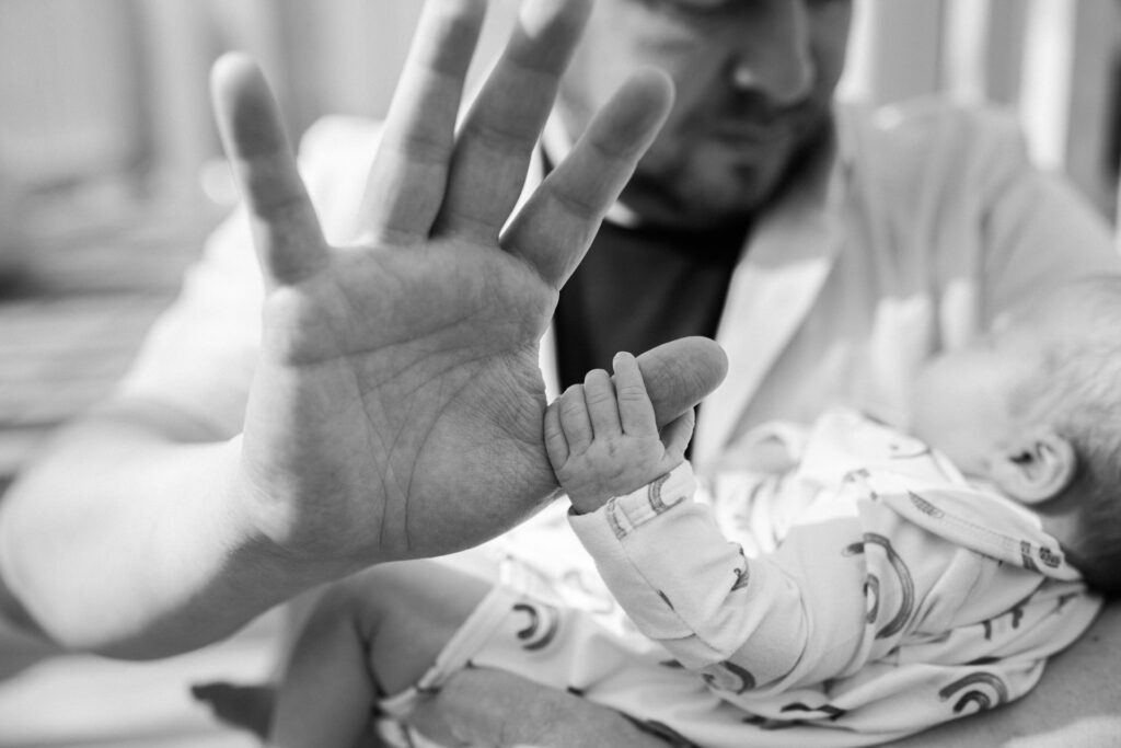 Newborn baby Luna grasps her dad's hand outside their home in Columbus Ohio