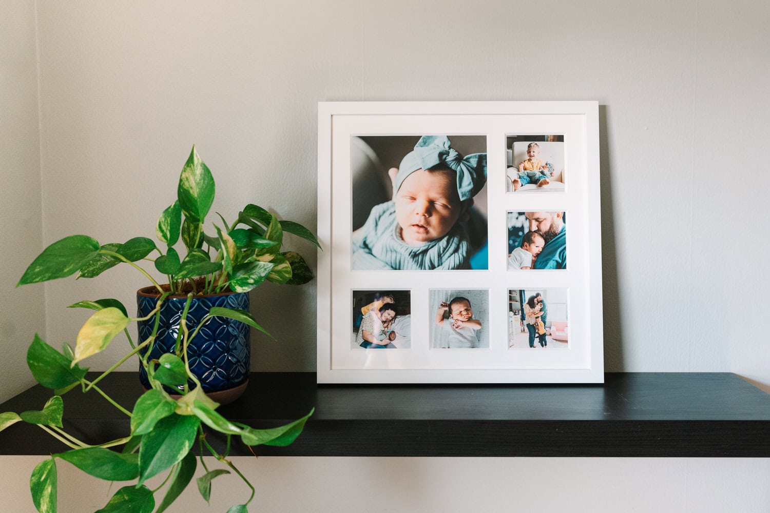 White photo frame containing newborn photos sitting on a shelf